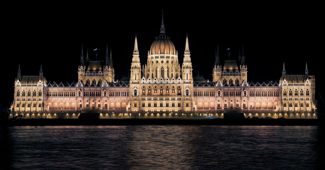 Budynek parlamentu w Budapeszcie po zmroku z brzegu Budy